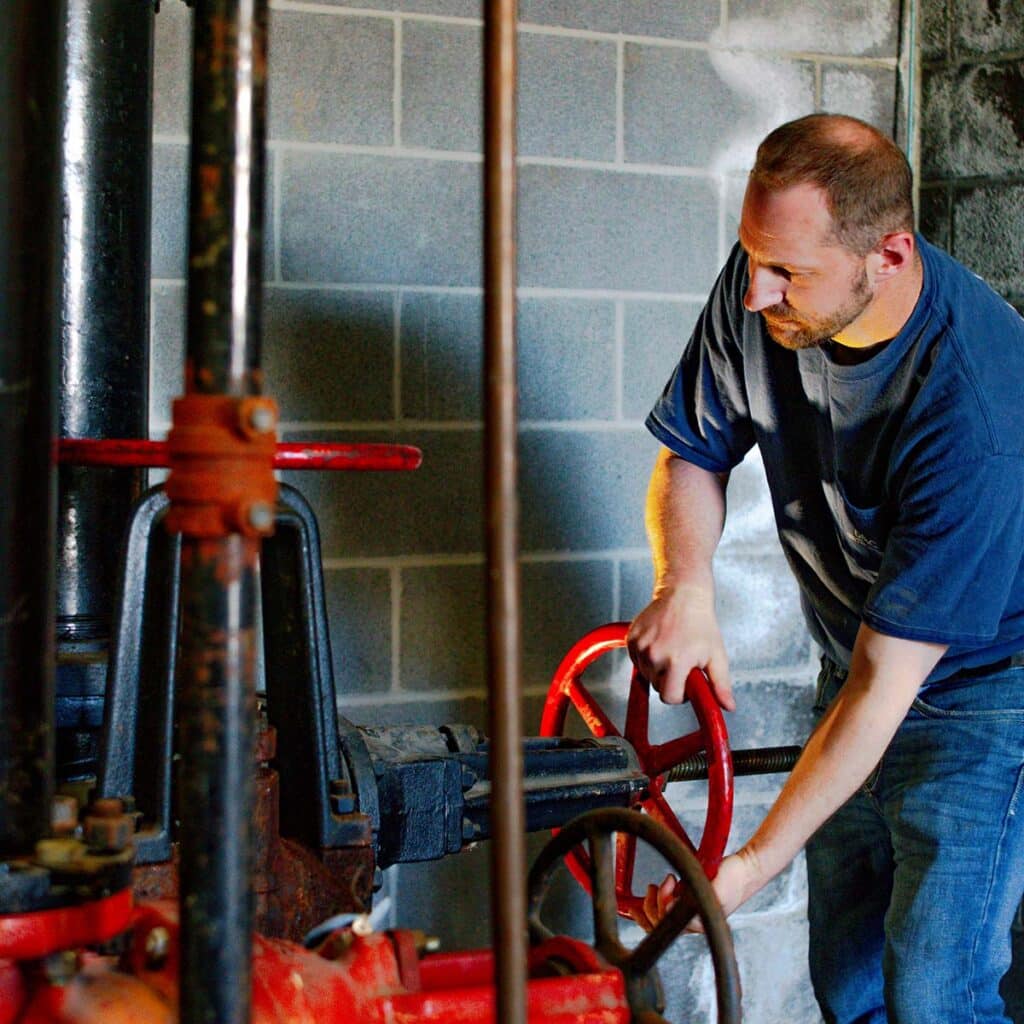 commercial plumber working on fixing a boiler